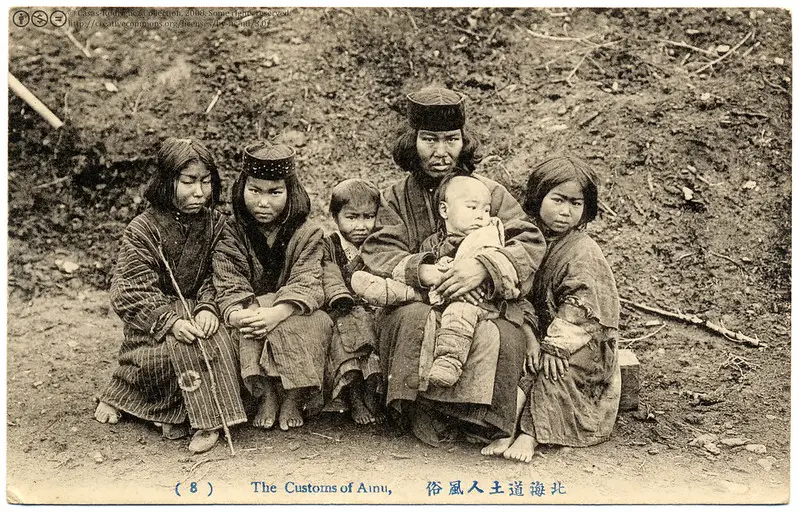 Eine alte Postkarte zeigt eine Ainu-Familie, die Ureinwohner Japans. Die Ainu kämpfen um die Bewahrung ihrer einzigartigen Kultur und Sprache, die stark von der japanischen Kultur abweicht.